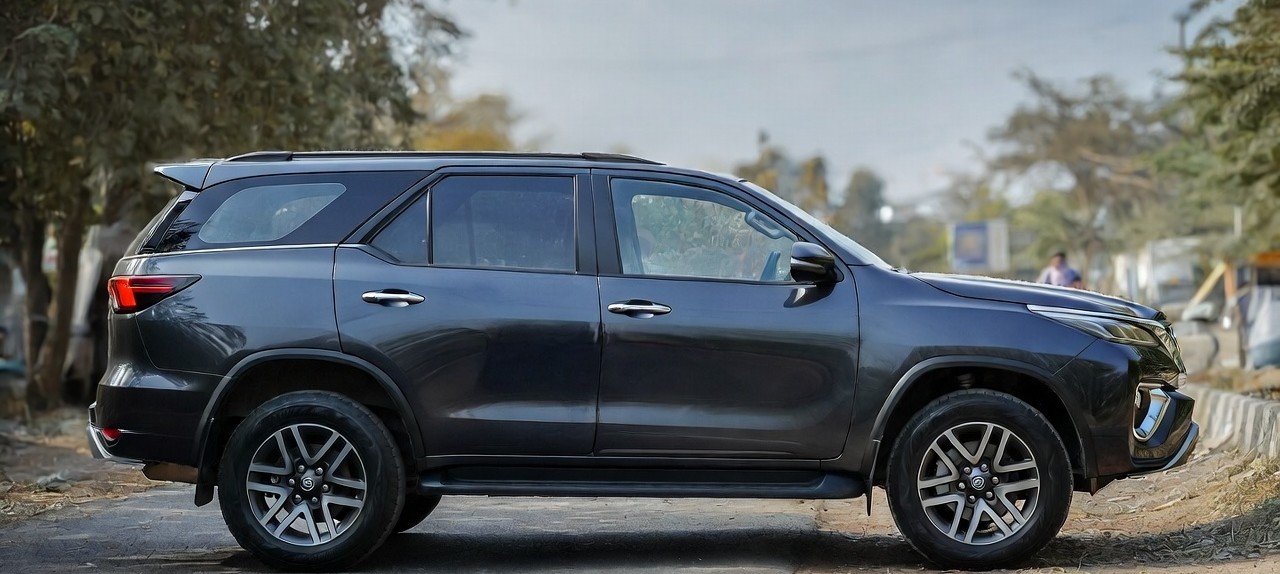 Toyota Fortuner side profile showing high ground clearance and large alloy wheels.