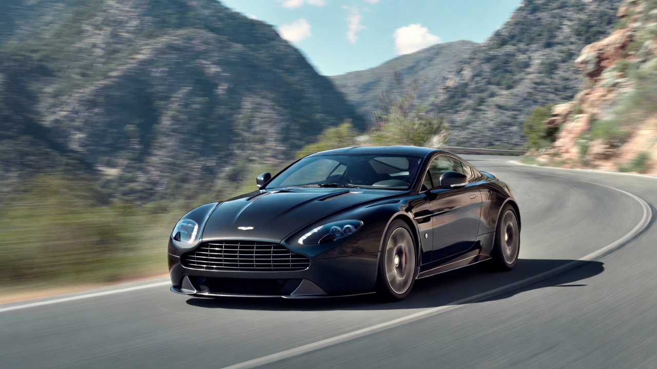 Aston Martin Vantage V8 driving on a winding road showcasing handling.