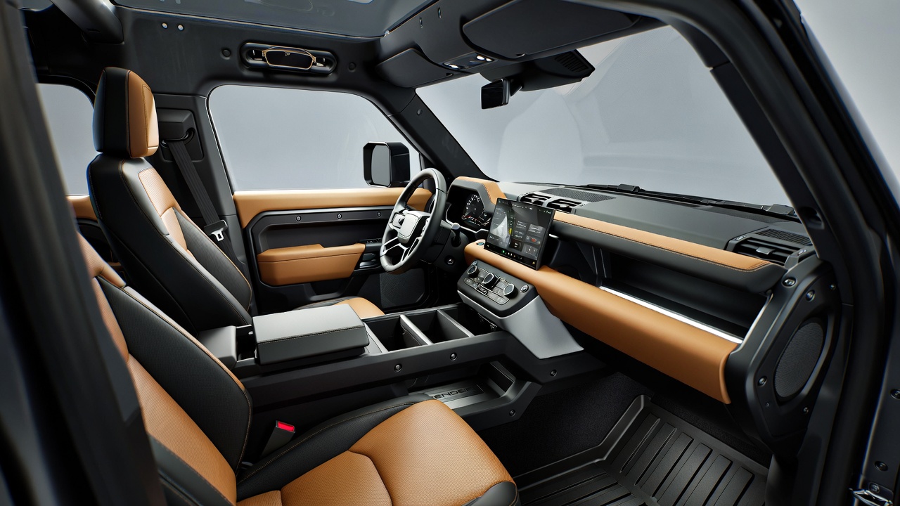 Land Rover Defender 110 interior with premium seats and touchscreen dashboard.