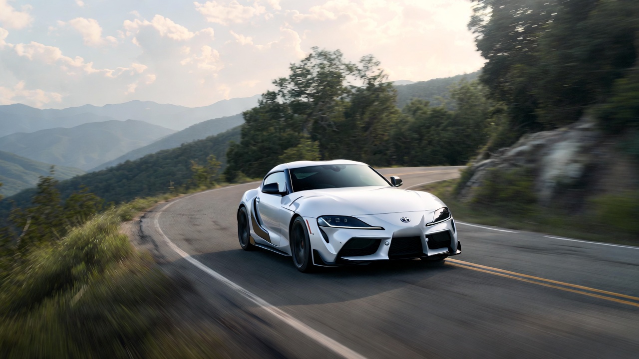 Toyota GR Supra cornering on mountain road showing real-world driving performance.