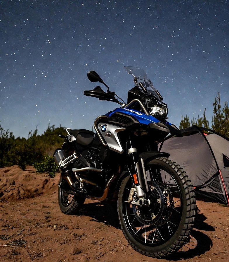 BMW F 450 GS parked at campsite under stars.