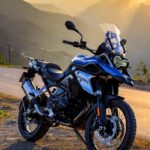 BMW F 450 GS adventure bike on mountain road at sunrise.