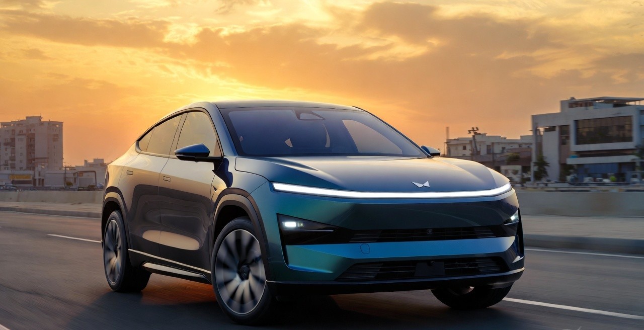 Mahindra XEV 9S futuristic electric SUV parked in Indian city at sunset.